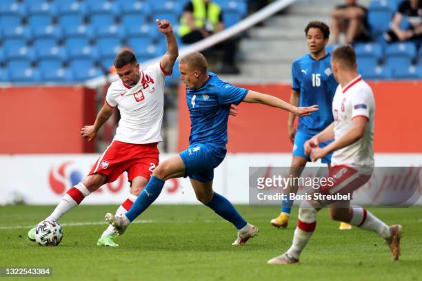 Jakub Swierczok of Poland is challenged by Hjortur Hermannsson of Iceland during the international friendly match between Poland and Iceland at...