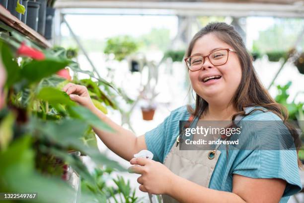 inclusión social : mujer con síndrome de down que trabaja en una pequeña empresa - down's syndrome fotografías e imágenes de stock