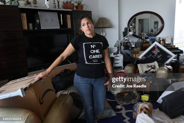 Maria Ray, who has lived at the Hamilton on the Bay apartment building for twelve years, stands in her apartment after attending a protest against...