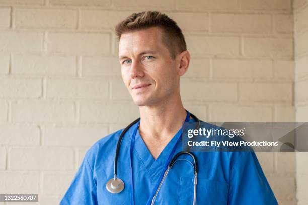 portrait of a male physician - doctor scrubs stock pictures, royalty-free photos & images