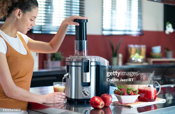 junge weibchen machen fruchtsaft - saftpresse stock-fotos und bilder