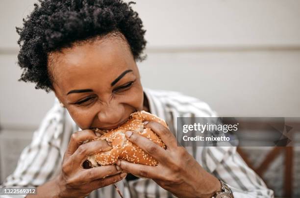 mmm, that was amazing - woman eating burger stock pictures, royalty-free photos & images