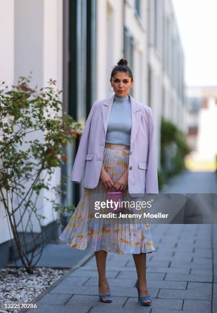 Anna Wolfers wearing blue crop top, colorful midi skirt, light purple blazer, all via Goldig Shop, blue heels and pink mini Aigner Munich bag on May...