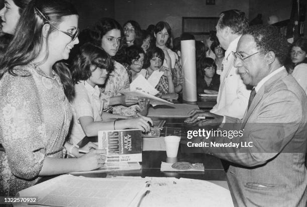 Author Alex Haley signs autographs at Islip Junior High School in Islip, New York on June 8, 1979. Haley visited the students after they had...