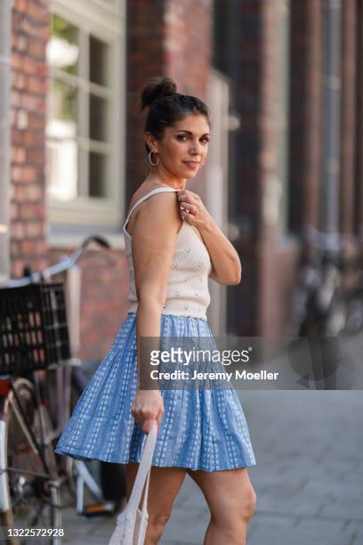 Anna Wolfers wearing beige top and blue mini skirt via Goldig Shop on May 31, 2021 in Hamburg, Germany.
