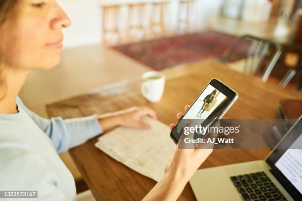 mujer recibiendo una notificación telefónica de alguien en la puerta de su casa - timbre de la puerta fotografías e imágenes de stock