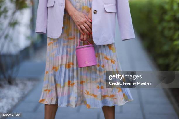 Anna Wolfers wearing blue crop top, colorful midi skirt, light purple blazer, all via Goldig Shop and pink mini Aigner Munich bag on May 31, 2021 in...