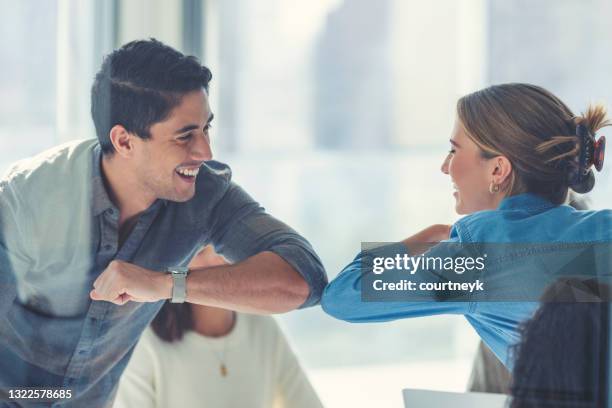 business people doing a covid handshake elbow bump during a business meeting. - covid handshake stock pictures, royalty-free photos & images