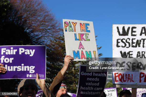 June 9: A male healthcare worker holds up an ironic sign 'pay me like a man' during a rally at Parliament in Wellington, New Zealand on June 09,...