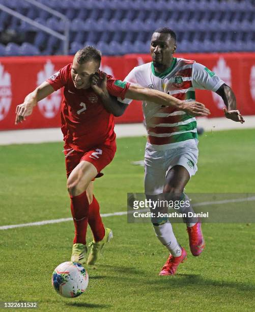 Alistair Johnston of Canada holds off Sheraldo Becker as he advances the ball during a FIFA World Cup Qualifier at SeatGeek Stadium on June 08, 2021...