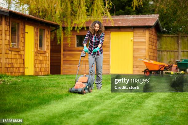 woman mowing her lawn - lawn mowing stock pictures, royalty-free photos & images