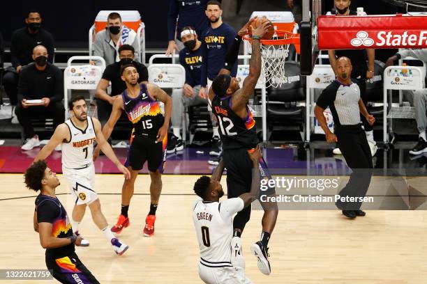 Torrey Craig of the Phoenix Suns slam dunks the ball over JaMychal Green of the Denver Nuggets after a pass from Cameron Payne during the second half...