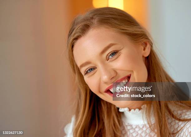 beautiful blond woman with toothy smile looking at camera indoors - beautiful romanian women stock pictures, royalty-free photos & images