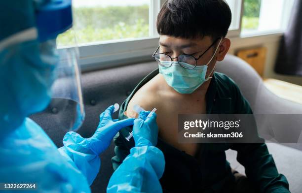 close up asian young adult  feeling relaxation and no concern with doctor vaccination covid-19(coronavirus) at vaccination center - drive through test stock pictures, royalty-free photos & images