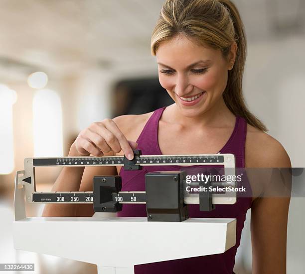 woman weighing herself - happiness scale stock pictures, royalty-free photos & images