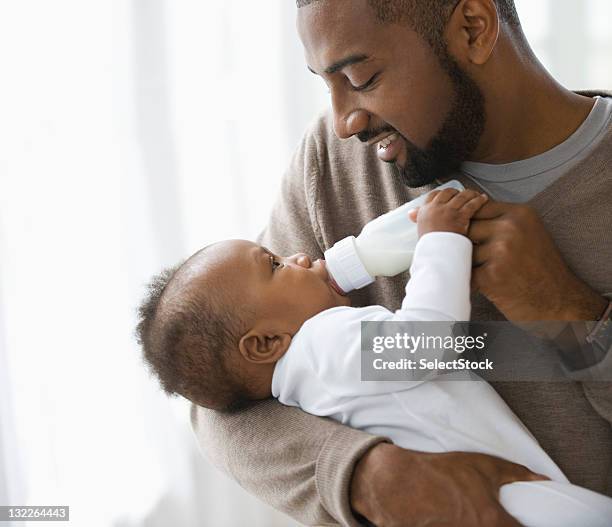 father feeding son - infant feeding stock pictures, royalty-free photos & images