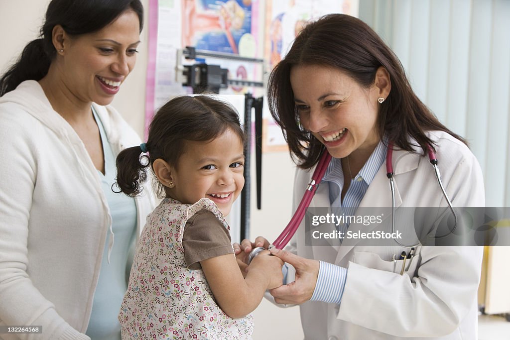 Toddler girl laughing while doctor examines