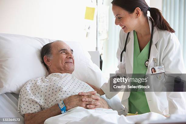 doctor checking on older man - hospital bracelet stock pictures, royalty-free photos & images