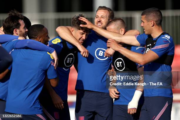 John Stones, Harry Kane, Luke Shaw and Conor Coady of England and teammates huddle during a training session at St George's Park on June 08, 2021 in...