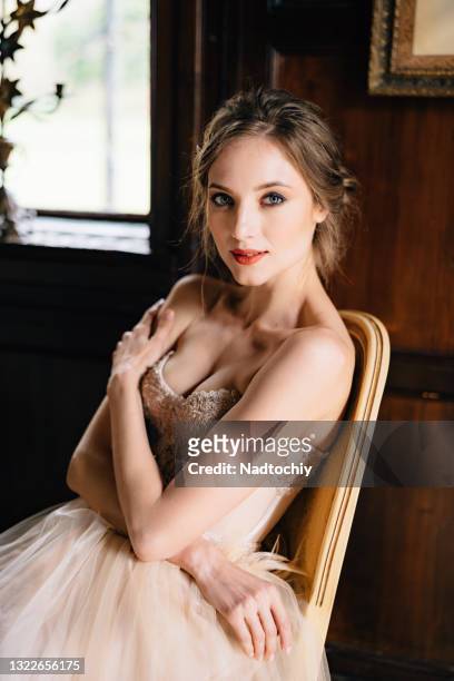 portrait of beautiful young woman sitting at home - evening gown stock pictures, royalty-free photos & images