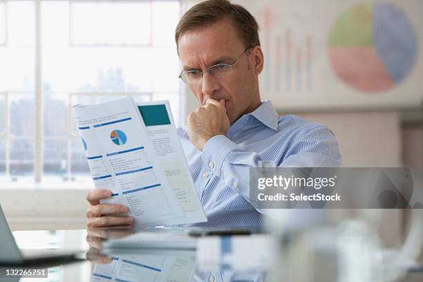 businessman looking over report - reading document stock pictures, royalty-free photos & images