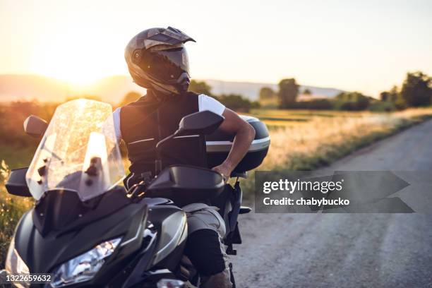 hombre en motocicleta disfruta en paseo al atardecer - biker fotografías e imágenes de stock