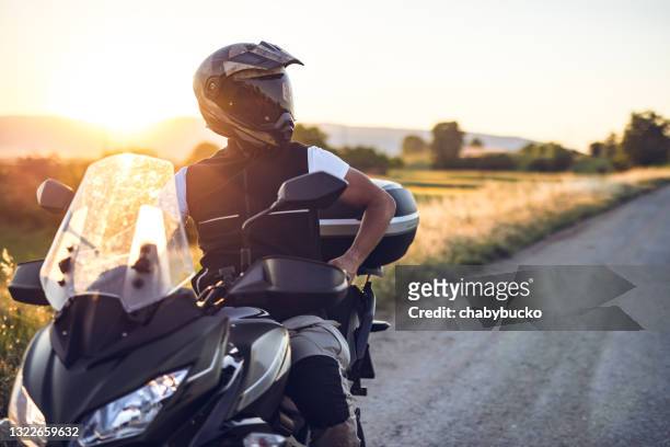 de mens op motorfiets geniet in rit bij zonsondergang - riding stockfoto's en -beelden
