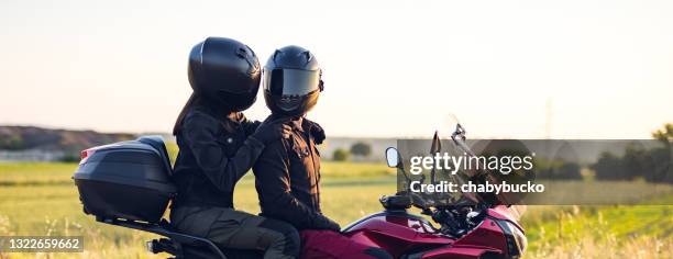 loving couple enjoys in motorcycle ride at sunset - motorcycle biker stock pictures, royalty-free photos & images