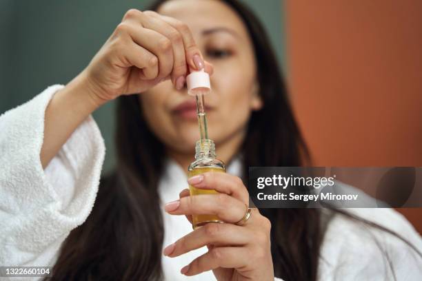 closeup shot of hands with face serum - skincare stockfoto's en -beelden