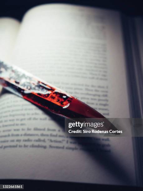 bloody knife on book - bloody knife stockfoto's en -beelden