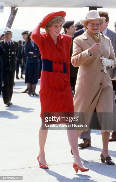 Diana, Princess of Wales, wearing a red pinstriped coat dress designed by Catherine Walker and a matching hat, walks next to wife of the Austrian...