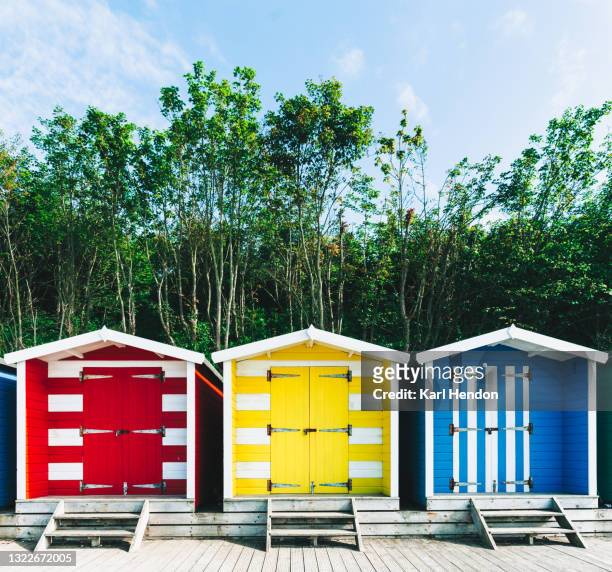 a daytime view of beach huts  - stock photo - isle of wight beach stock pictures, royalty-free photos & images