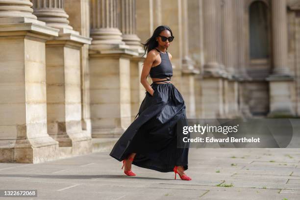 Emilie Joseph @in_fashionwetrust wears a black solid strap detail tank-top and matching midi skirt from mango, red mesh sandals by Bottega Veneta...