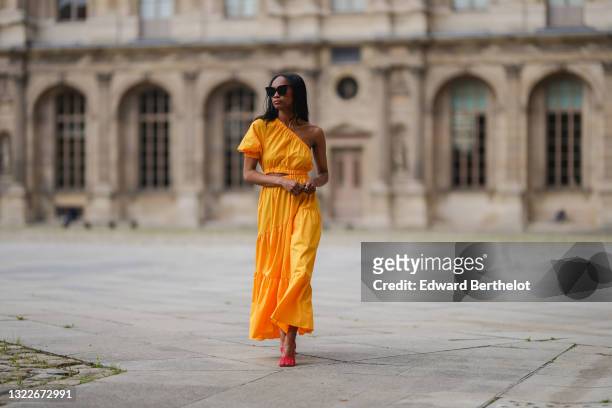Emilie Joseph @in_fashionwetrust wears a yellow asymmetric cut-out midi dress from Mango, red mesh toe-cap strappy pumps heels shoes from Bottega...