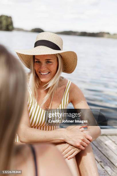 smiling woman in straw hat relaxing at lake - scandinavian woman blond stock pictures, royalty-free photos & images