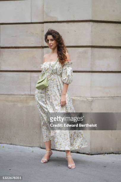 Ketevan Giorgadze @katie.one wears gold earrings, a long white with green and beige flower pattern / floral print off-shoulder and puffy / bell...