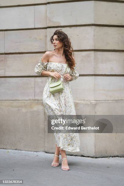 Ketevan Giorgadze @katie.one wears gold earrings, a long white with green and beige flower pattern / floral print off-shoulder and puffy / bell...