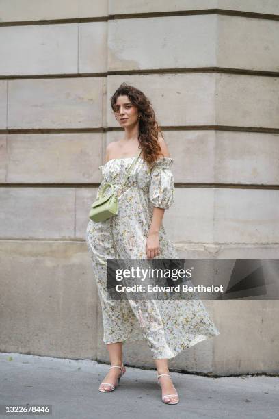 Ketevan Giorgadze @katie.one wears gold earrings, a long white with green and beige flower pattern / floral print off-shoulder and puffy / bell...