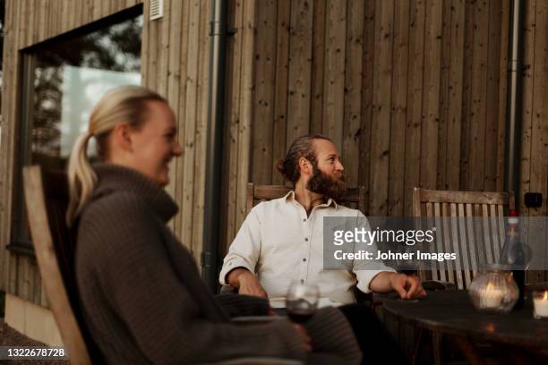 friends sitting on porch and drinking wine - wijn tuin stockfoto's en -beelden