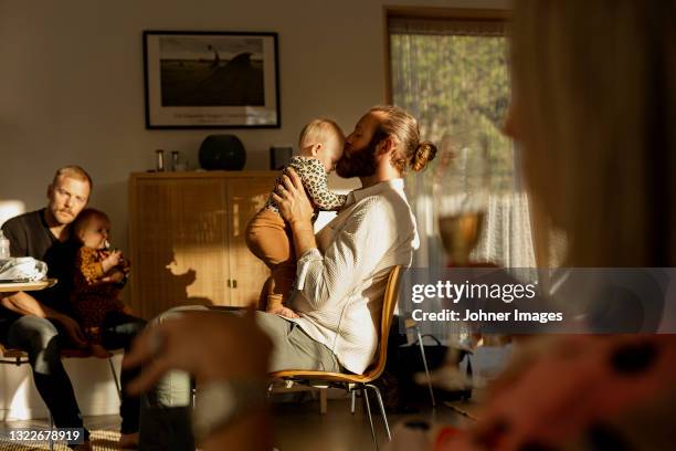 fathers with their babies resting in living room - living room kids stockfoto's en -beelden