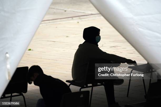 People sit in the recovery area at a rapid vaccination centre set up outside Bolton Town Hall on June 09, 2021 in Bolton, England. To help curb the...