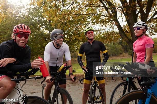cyclists relaxing on roadside - cycling group stock-fotos und bilder