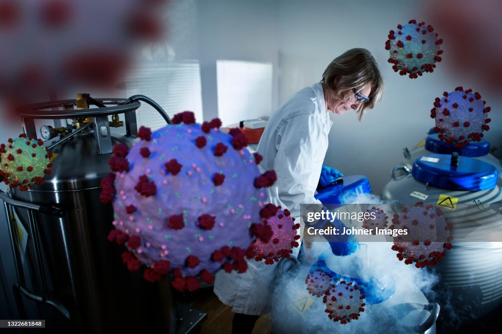 Scientist removing samples from storage tank of liquid nitrogen
