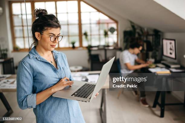 portrait of confident young freelancer in new home office setup - denim shirt stock pictures, royalty-free photos & images