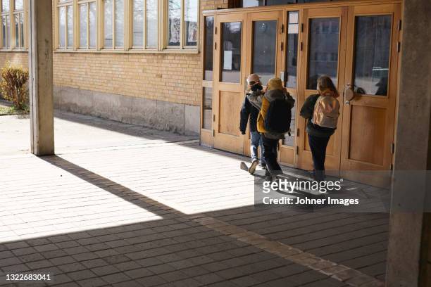 children entering school - school building entrance stock pictures, royalty-free photos & images