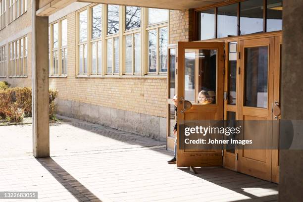 children at school entrance door - school building entrance stock pictures, royalty-free photos & images