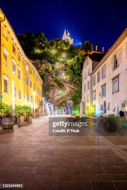 clock tower landmark on high mountain in center of graz city with flower and tourist teenage travel and sit after dinner for sunset time with night star above restaurant and apartment, in graz beautiful and peaceful city in alps mountain in austria, europ - graz austria stock pictures, royalty-free photos & images