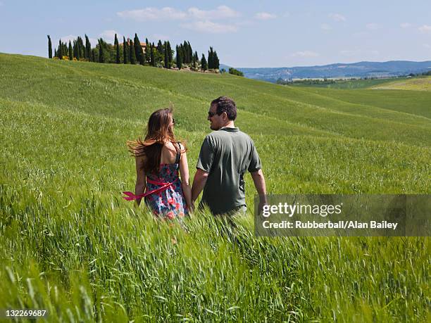 italia, toscana, vista posteriore di una coppia a piedi sul prato - man in dress foto e immagini stock