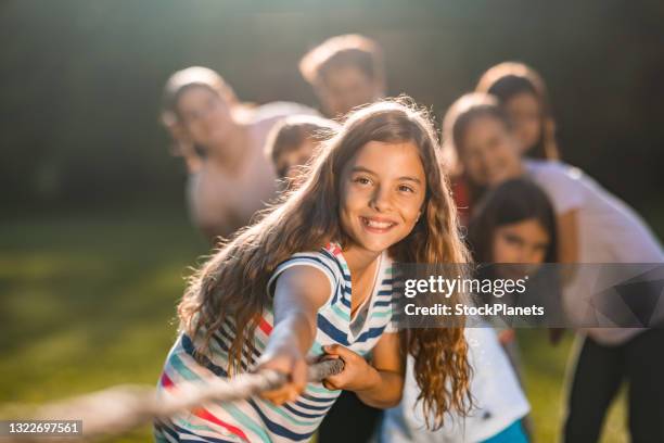 gruppe von kindern in einem tauziehen spiel im freien - freizeit sport und spiel stock-fotos und bilder