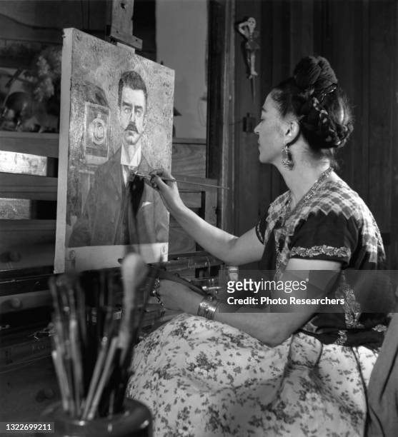 View of Mexican artist Frida Kahlo as she paints her father's portrait, Mexico, 1952.